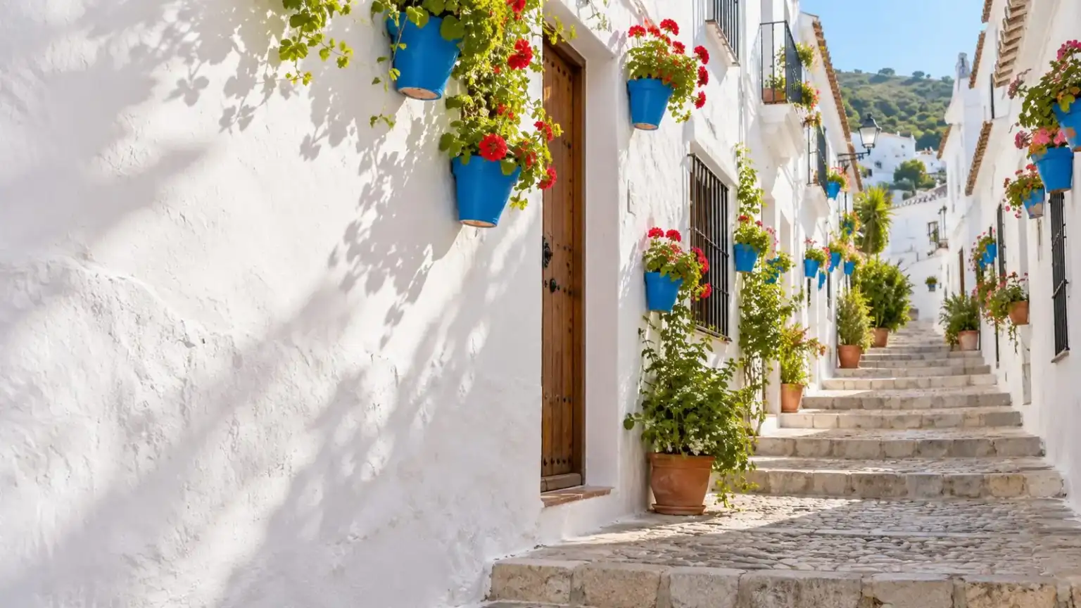 Abogado Frigiliana 1 - abogado Nerja, abogado Torrox, abogado Velez Malaga, abogado Torre del Mar Calle encalada con escalones y macetas en un pueblo blanco de la Axarquía